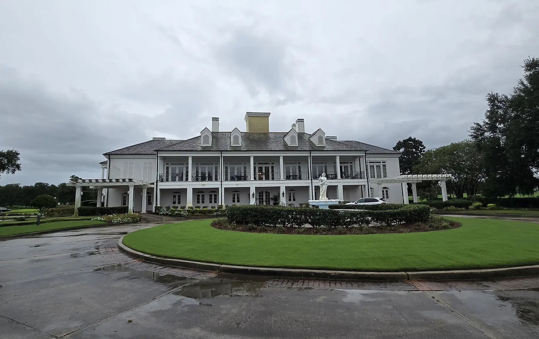 The columned clubhouse of 1914 across its forecourt circle, beneath a wide Piedmont sky