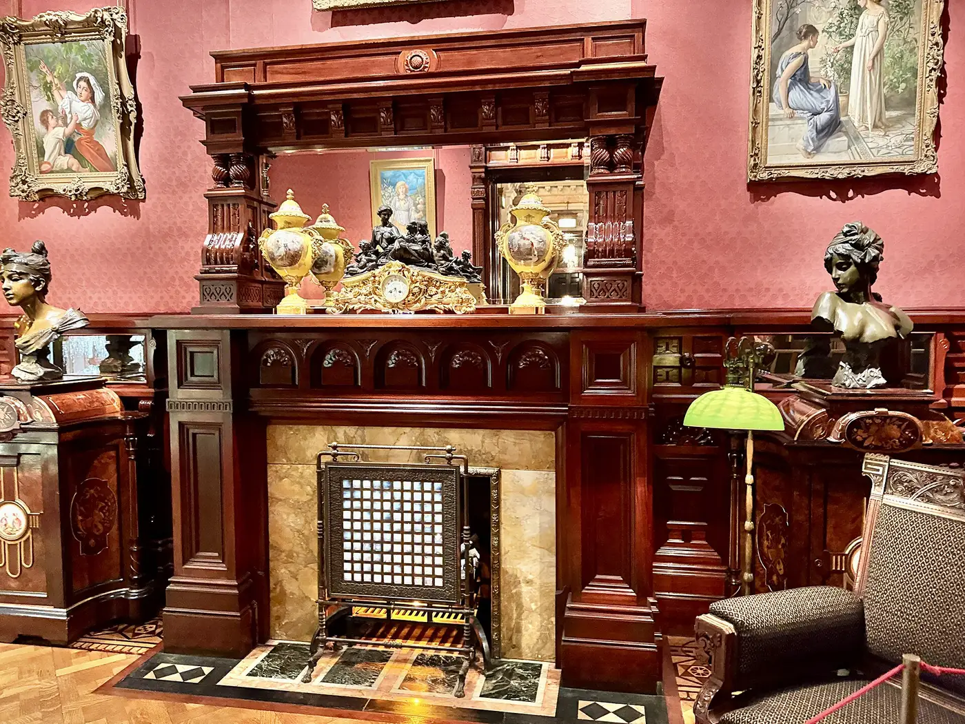 The Card Room hearth, with its carved chimneypiece and the leather chairs drawn close