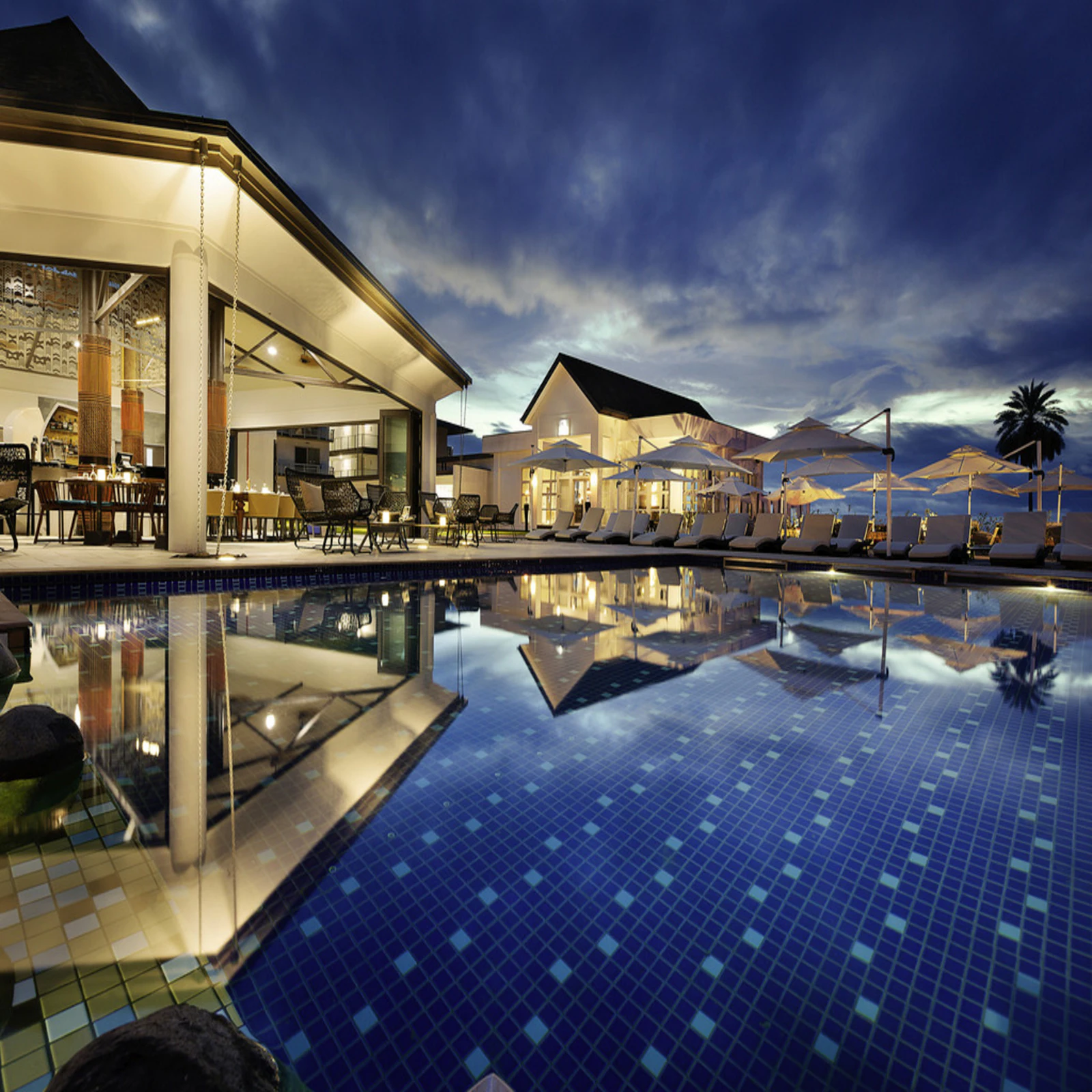 The pools at dusk, the underwater lights on and the terrace gone quiet