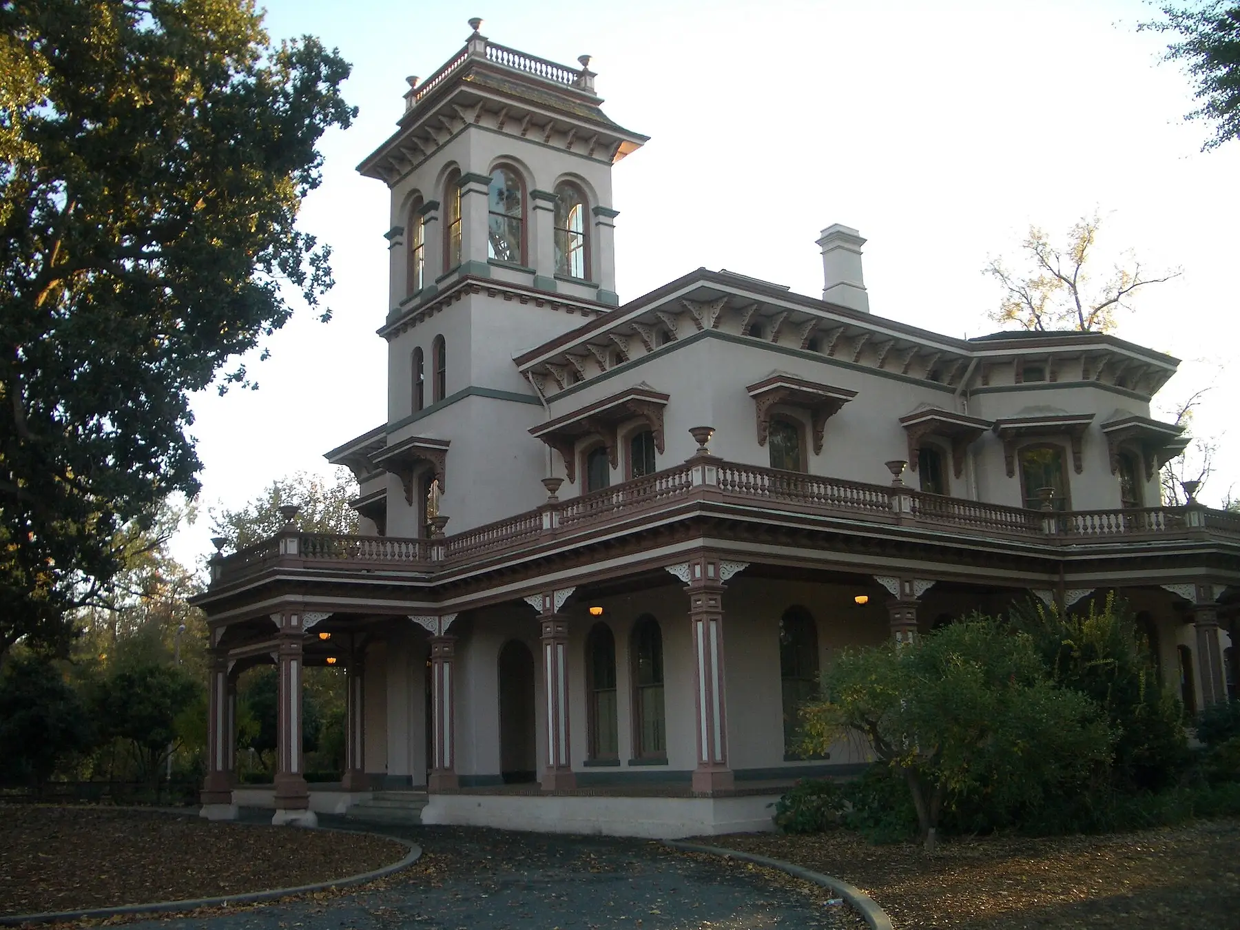 The clubhouse from the forecourt on a bright morning, its veranda and tower above the boxwood
